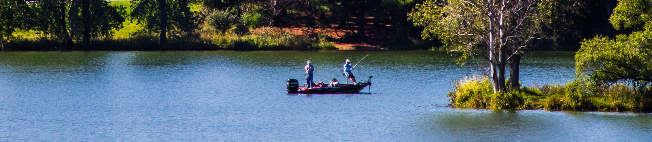 Two men out fishing on a small motor boat on a lake